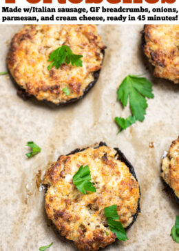Pinterest pin with stuffed portobello mushrooms on a sheet pan with parchment paper, topped with fresh chopped parsley.