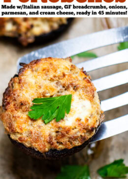 Pinterest pin with a sheet pan of stuffed portobello mushrooms with a spatula lifting up a mushroom topped with fresh chopped parsley.