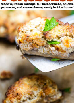 Pinterest pin with a sheet pan of stuffed portobello mushrooms with a spatula lifting up half a mushroom topped with fresh chopped parsley.