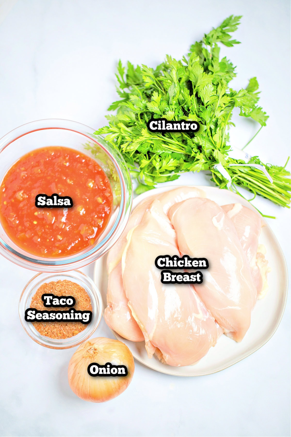 Individual ingredients for slow cooker chicken tacos on a table.