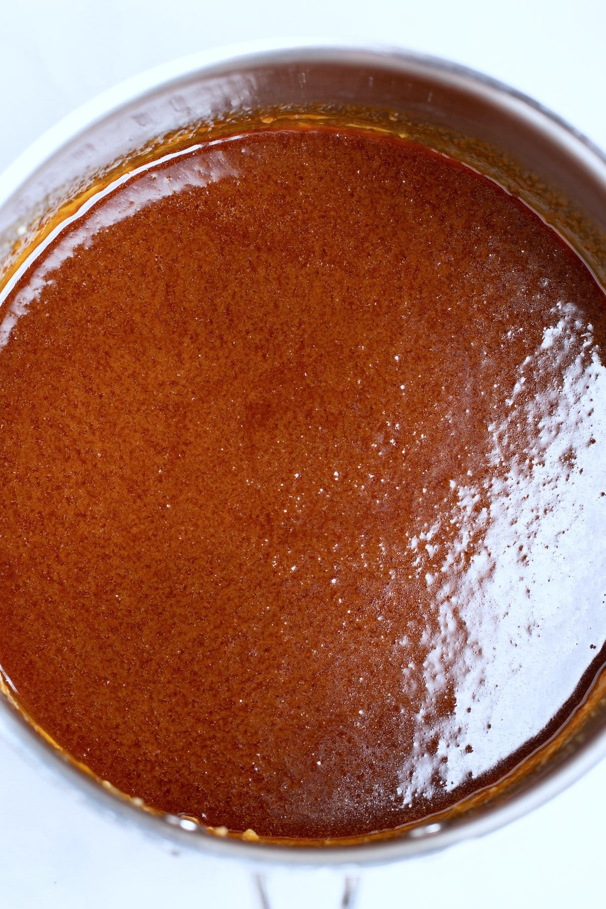 A saucepan with finished caramel sauce in it.