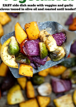 Pinterest pin with roasted vegetables on top of parchment paper on a sheet pan, with a spatula in the middle lifting some vegetables up, just out of the oven.