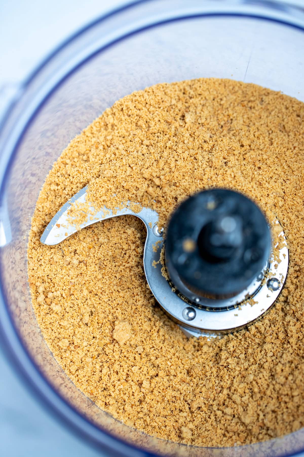 A food processor full of graham cracker crumbs.