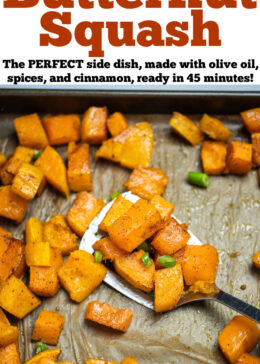 Pinterest pin with a sheet pan lined with parchment paper with a single layer of roasted butternut squash, topped with green onions, and a spatula lifting up some pieces of squash.