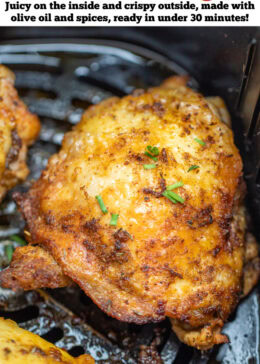 Pinterest pin with chicken thighs in an air fryer basket with chopped chives on top of crispy skin.