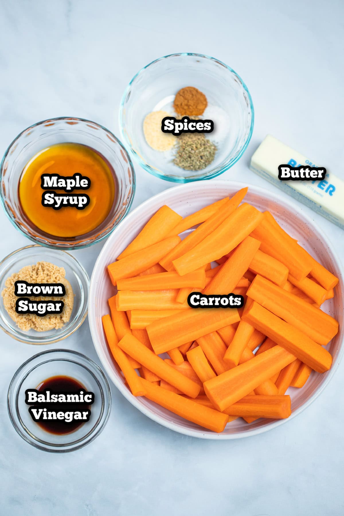 Individual ingredients for maple glazed carrots on a table.