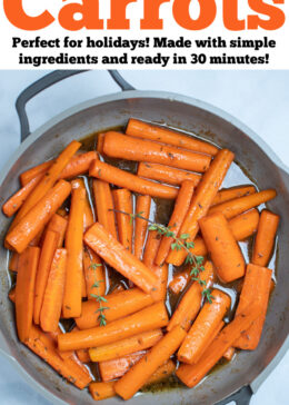 Pinterest pin with a skillet with cooked maple glazed carrots with fresh thyme sprigs on top, resting on a table.