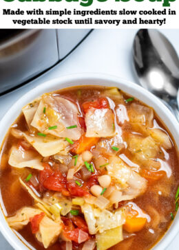 Pinterest pin with a bowl of slow cooker cabbage soup on the table, with a spoon next to the soup, in front of a slow cooker.