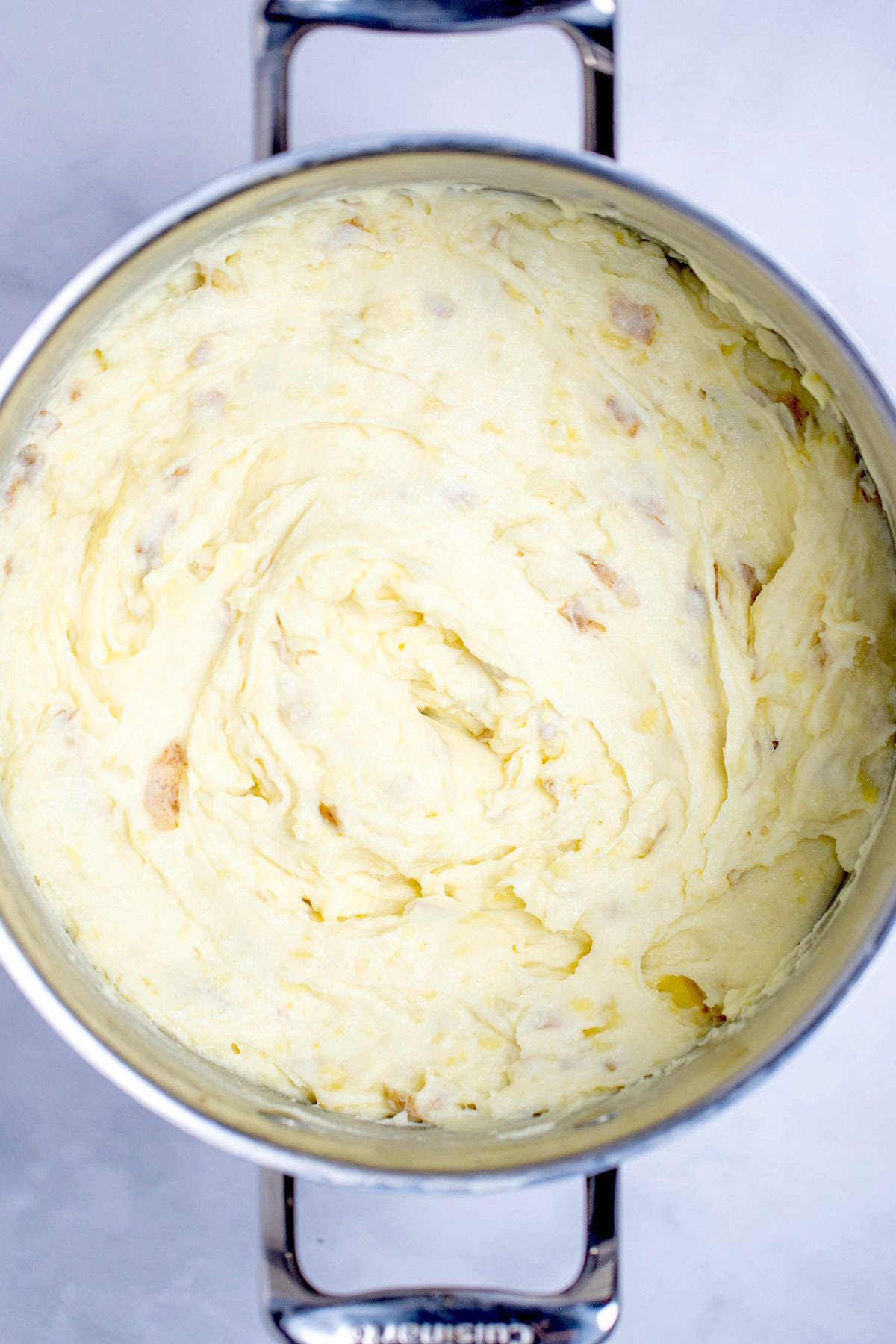 A stockpot full of mashed potatoes on a table.