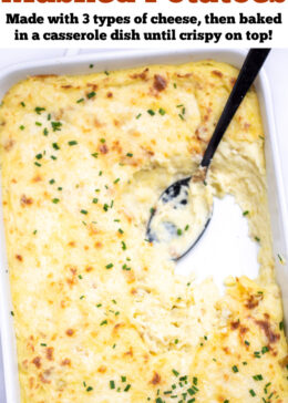 Pinterest pin with a casserole dish full of twice baked mashed potatoes with caramelized cheese on top with fresh chopped chives, with a spoon resting in an empty spot in the dish.