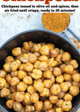 Pinterest pin with a bowl on a table with crispy air fryer chickpeas coated in seasoning, with a measuring cup of spices in the background.