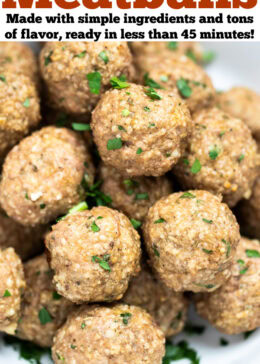 Pinterest pin with a bowl full of baked turkey meatballs topped with fresh chopped parsley, on a table.