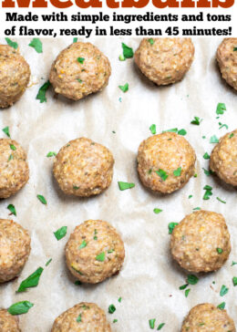 Pinterest pin with baked turkey meatballs on a sheet pan lined with parchment paper, fully cooked and topped with fresh chopped parsley.