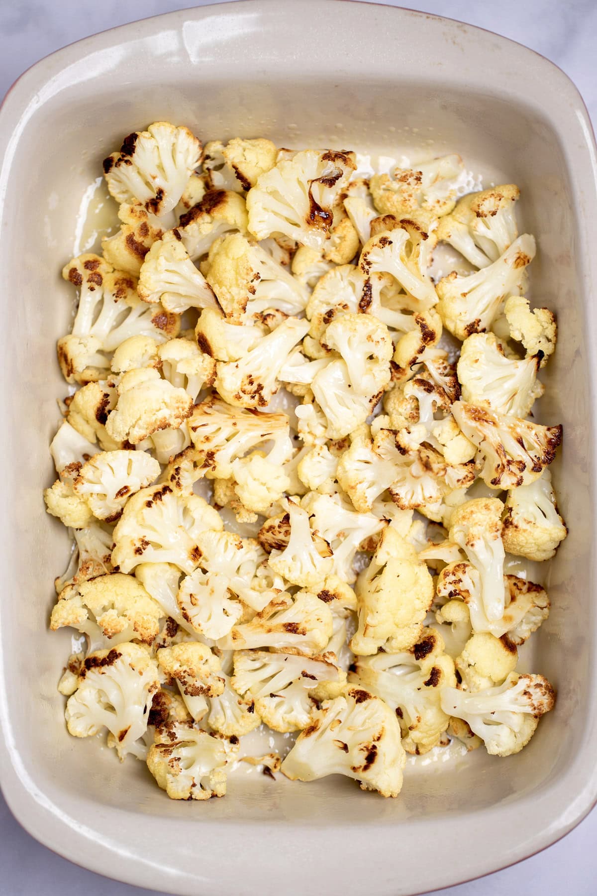 A baking dish full of roasted cauliflower florets.