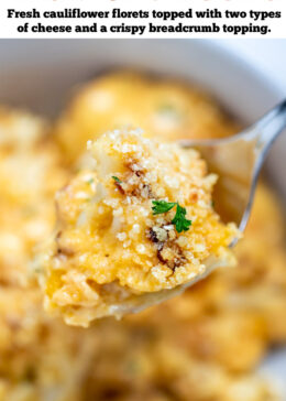 Pinterest pin with a spoon lifting up cauliflower mac and cheese from a bowl, topped with fresh chopped parsley.