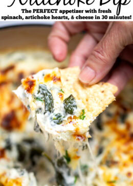 Pinterest pin with a dutch oven full of spinach artichoke dip with a caramelized top, topped with chopped green onions, with a hand holding a tortilla chip scooping up some dip.