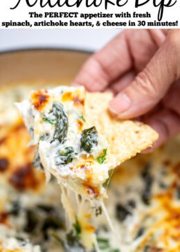 Pinterest pin with a dutch oven full of spinach artichoke dip with a caramelized top, topped with chopped green onions, with a hand holding a tortilla chip scooping up some dip.