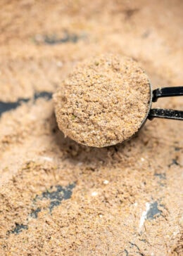 Pinterest pin with a closeup in a bowl of fajita seasoning, with a tablespoon full of seasoning resting in the bowl.