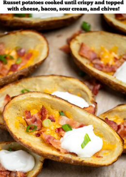 Pinterest pin with loaded potato skins topped with cheese, bacon, green onions, and sour cream on a sheet pan.