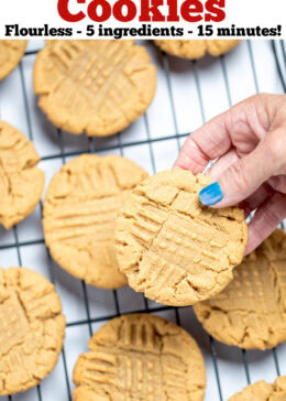 Pinterest pin with a hand holding a gluten free peanut butter cookie over a cookie rack of cooling cookies.