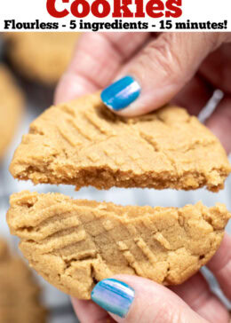 Pinterest pin with a hand breaking a peanut butter cookie in half over a rack of cooling cookies.