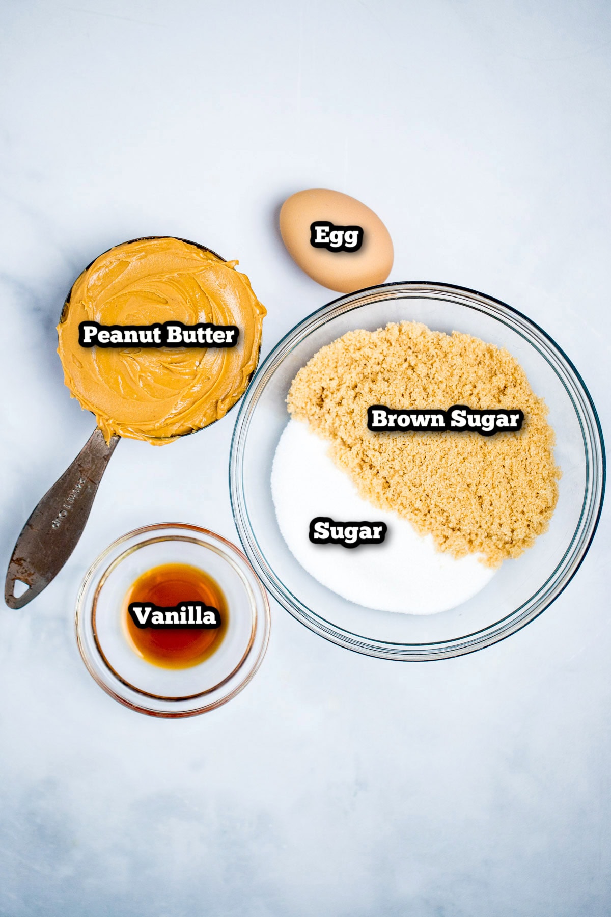 Individual ingredients for gluten free peanut butter cookies on a table.